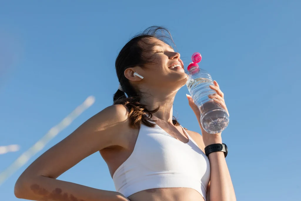 Woman drinking water after exercising, representing compounded women's health treatments
