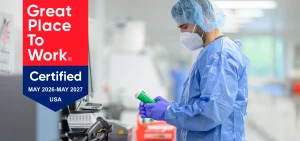 MediVera Compounding Pharmacy team member working in a compounding lab alongside the Great Place To Work Certified badge, May 2026–May 2027, USA